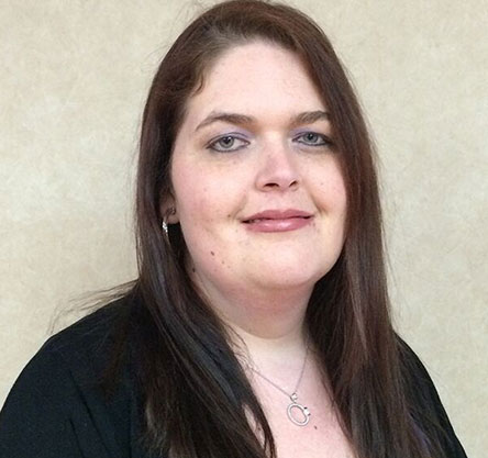 Picture of a women with a silver necklace and brown hair posing for the camera.