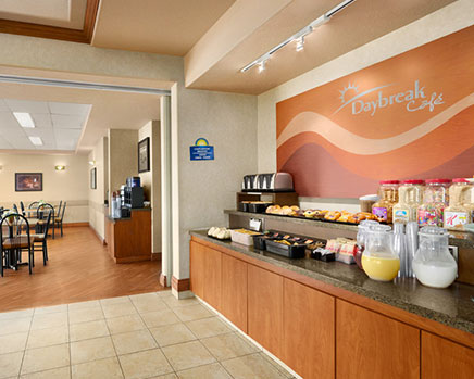 The breakfast bar stocked with many choices of baked goods, fruits and cereals, stands side by side with the coffee kiosk at Days Inn Red Deer, Alberta.