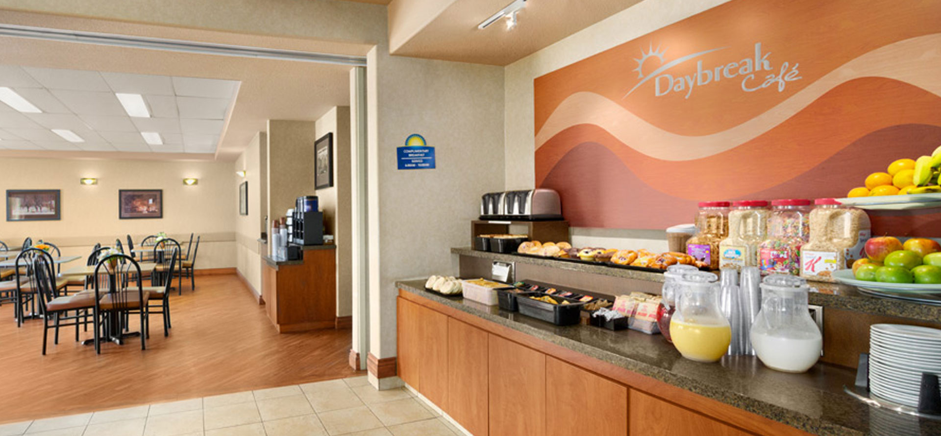 Large view of the breakfast room at Days Inn Red Deer, Alberta overlooking the stocked breakfast bar, coffee kiosk and dining area.
